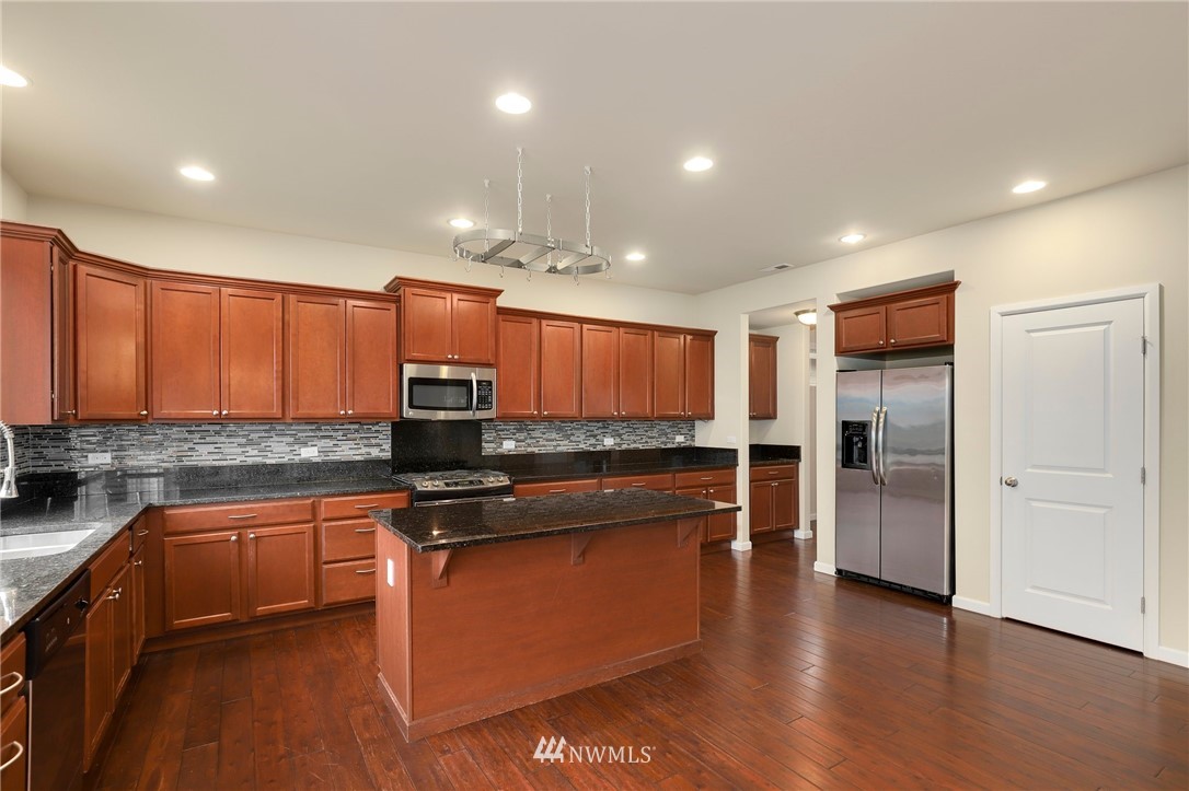 7301 Radius Loop Southeast Lacey, WA 98513 - Photo 6 of 39 a kitchen with stainless steel appliances granite countertop a stove a sink and a refrigerator