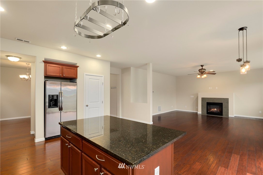 7301 Radius Loop Southeast Lacey, WA 98513 - Photo 7 of 39 a open kitchen with stainless steel appliances granite countertop a sink dishwasher and a stove with wooden floor
