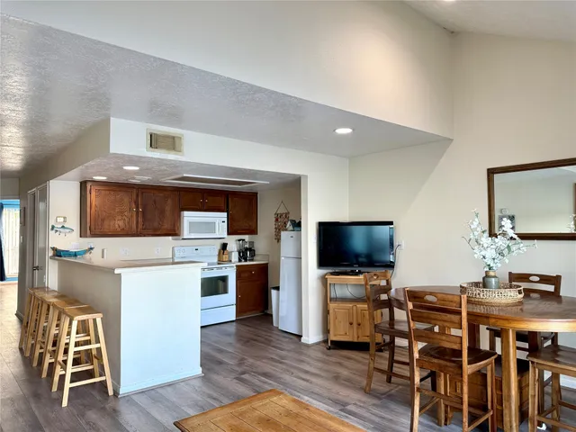 a kitchen with stainless steel appliances wooden floor and a refrigerator