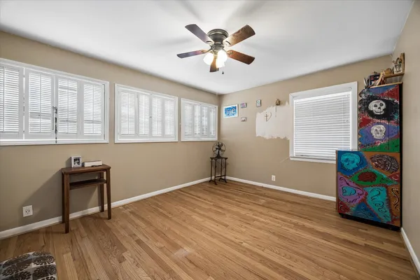 a view of an empty room with window and wooden floor