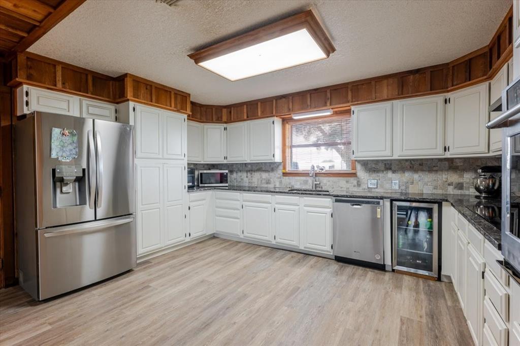 199 Willingham Loop Seymour, TX 76380 - Photo 11 of 40 a kitchen with granite countertop a refrigerator stove top oven and sink