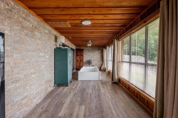 a view of a hallway with wooden floor and a large window