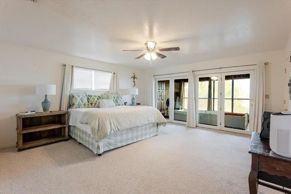 a spacious bedroom with a bed and a chandelier