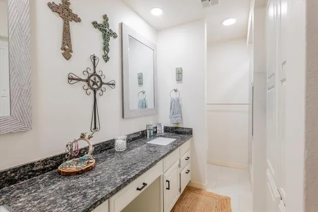 a bathroom with a granite countertop sink and a mirror