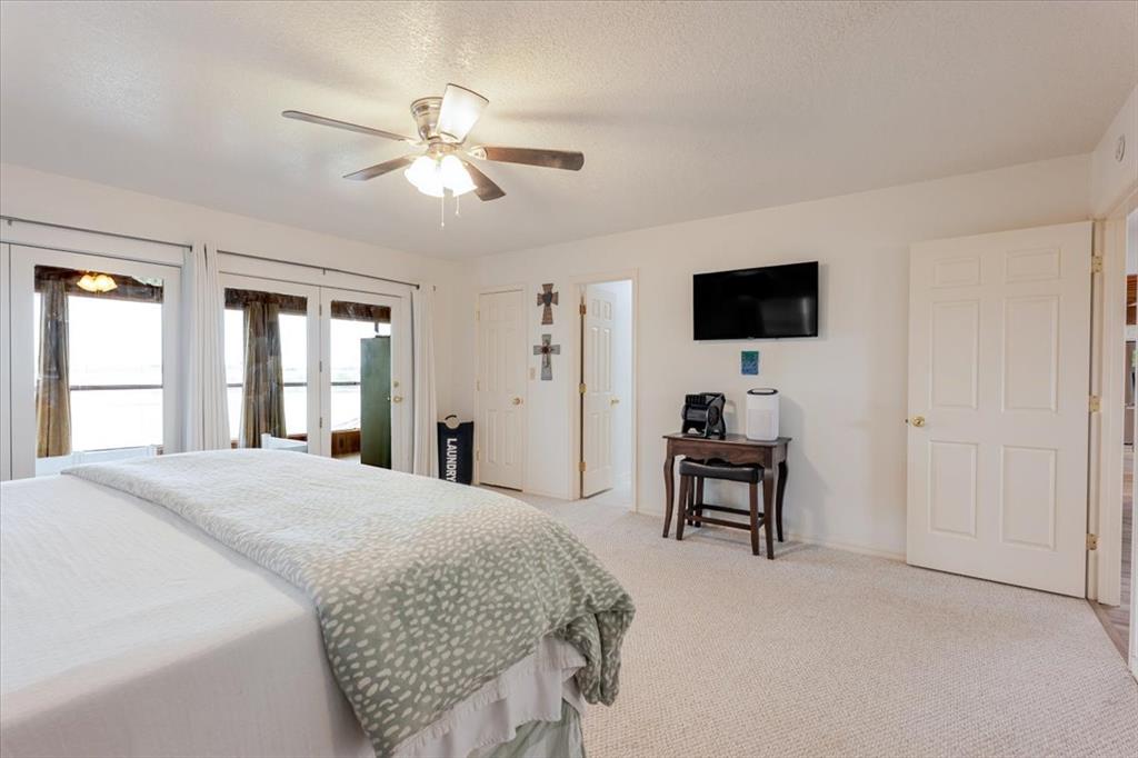 199 Willingham Loop Seymour, TX 76380 - Photo 16 of 40 a spacious bedroom with a bed and a flat screen tv