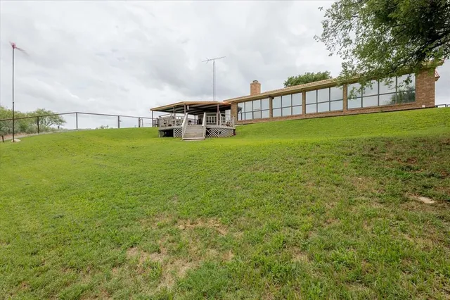 a view of a house with a big yard and sitting area