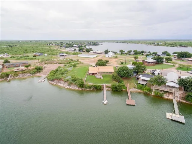 an aerial view of ocean with residential house and outdoor space