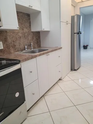 a room with a sink a washer and dryer