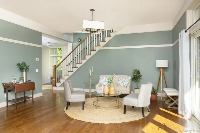a living room with furniture and a dining table with wooden floor