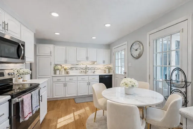 a kitchen with granite countertop a sink appliances cabinets and furniture