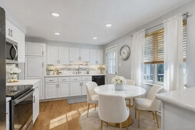 a kitchen with granite countertop white cabinets and stainless steel appliances