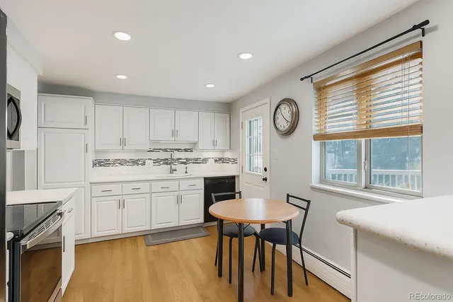 a kitchen with granite countertop white cabinets and stainless steel appliances