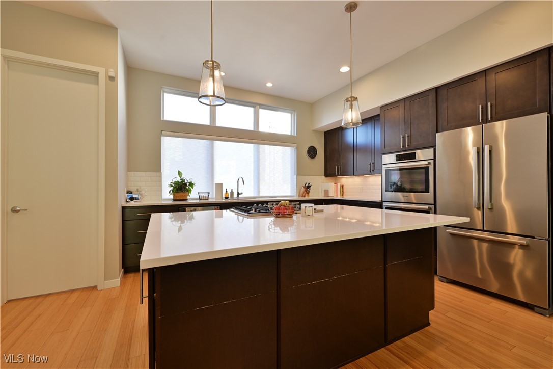 18875 Riversouth Fairview Park, Unit 30 Cleveland, OH 44126 - Photo 9 of 39 Kitchen featuring stainless steel appliances, dark brown cabinets, decorative light fixtures, light wood-type flooring, and recessed lighting
