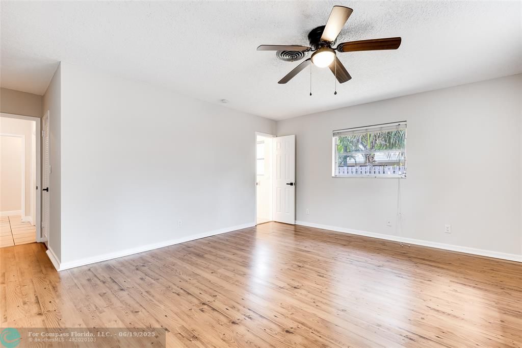 3460 Northeast 28th Avenue Lighthouse Point, FL 33064 - Photo 12 of 37 a view of room with hardwood floor ceiling fan and window