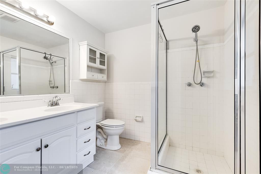 3460 Northeast 28th Avenue Lighthouse Point, FL 33064 - Photo 16 of 37 a bathroom with a toilet sink a mirror and shower