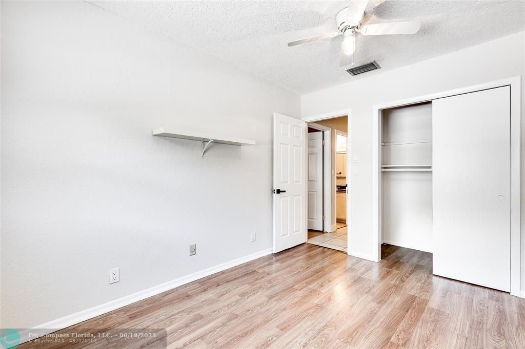 3460 Northeast 28th Avenue Lighthouse Point, FL 33064 - Photo 20 of 37 an empty room with wooden floor and a ceiling fan