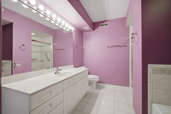 a bathroom with a sink a vanity a mirror and a toilet
