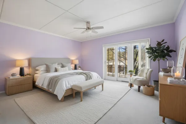 a spacious bedroom with a bed a chandelier and a couch