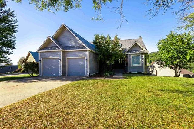a front view of house with yard and trees in the background