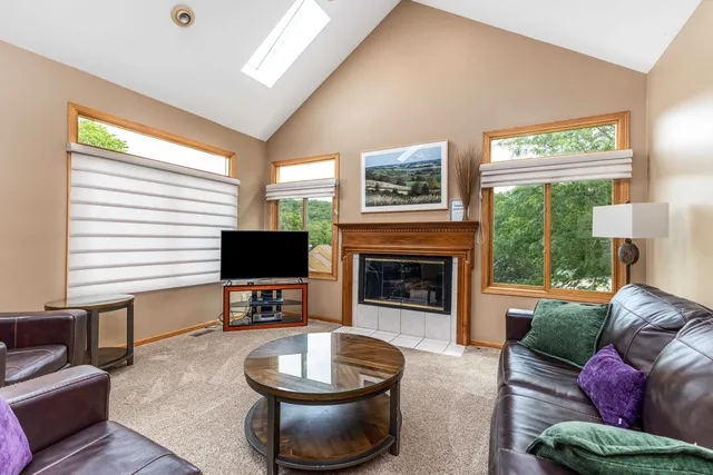 a living room with furniture a fireplace and a large window