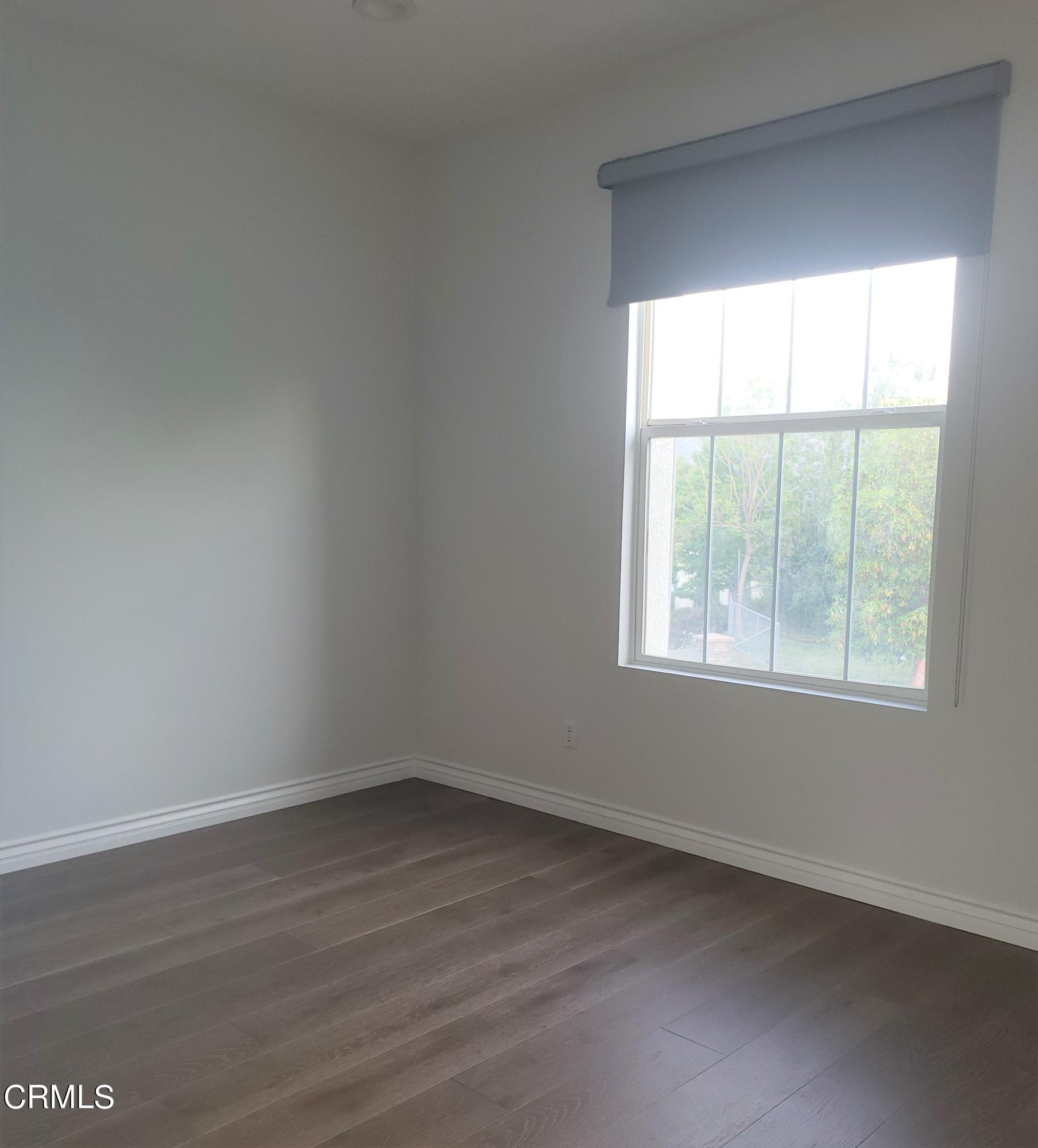 7454 Chanteclair Court Tujunga, CA 91042 - Photo 20 of 25 an empty room with wooden floor and windows