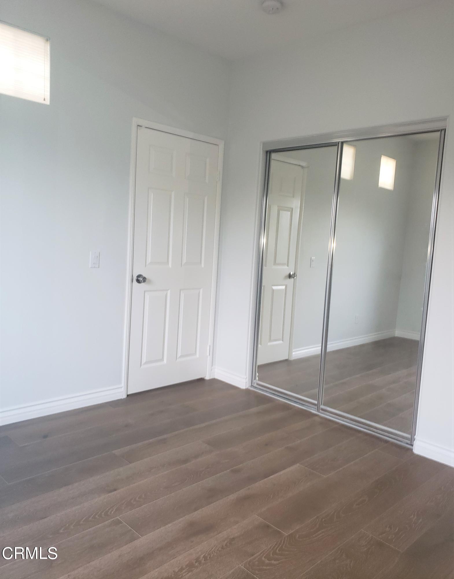 7454 Chanteclair Court Tujunga, CA 91042 - Photo 21 of 25 a view of an empty room with wooden floor and mirror