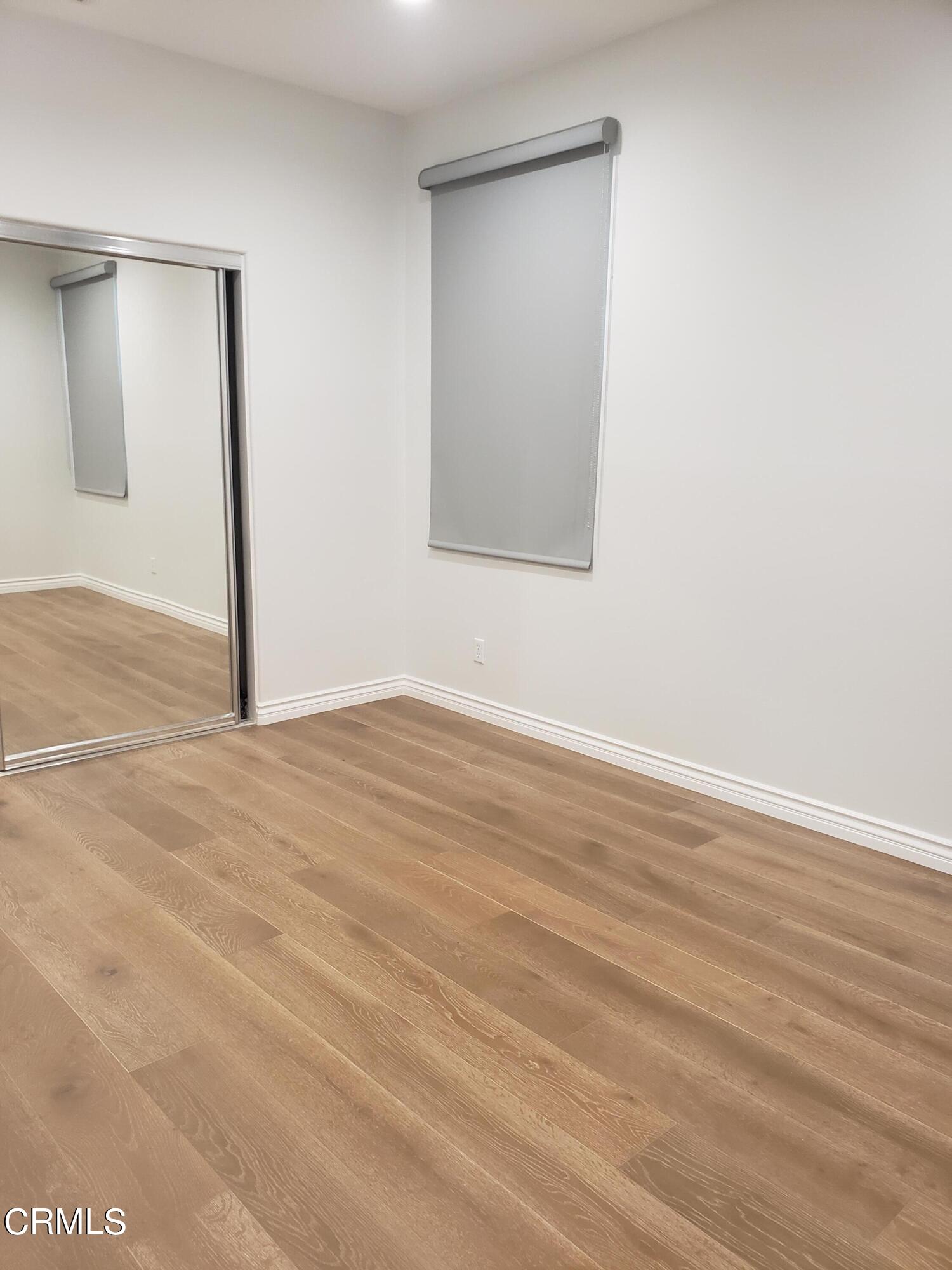 7454 Chanteclair Court Tujunga, CA 91042 - Photo 23 of 25 an empty room with wooden floor and windows