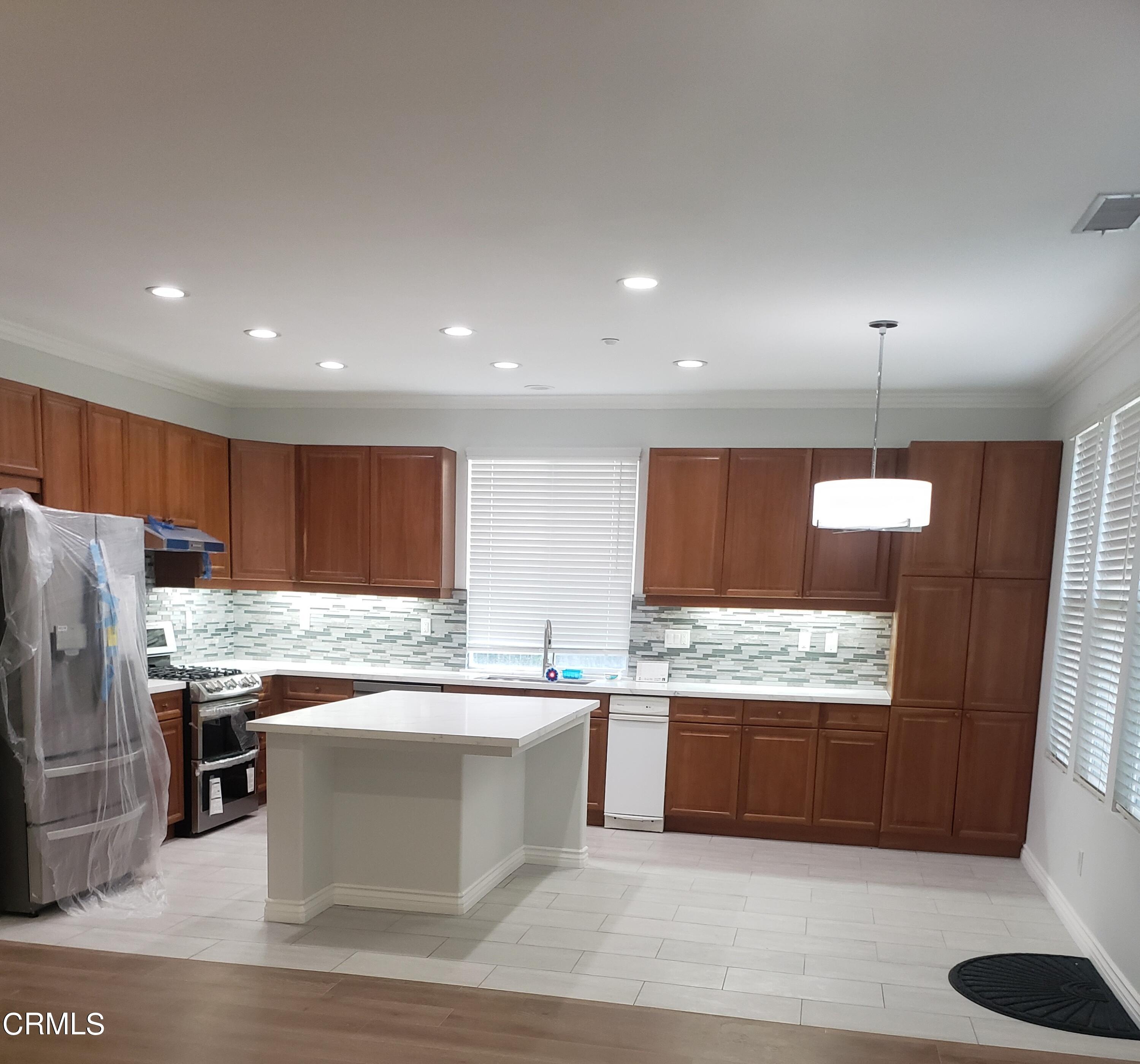7454 Chanteclair Court Tujunga, CA 91042 - Photo 5 of 25 a kitchen with stainless steel appliances kitchen island granite countertop a refrigerator a sink a stove and a microwave