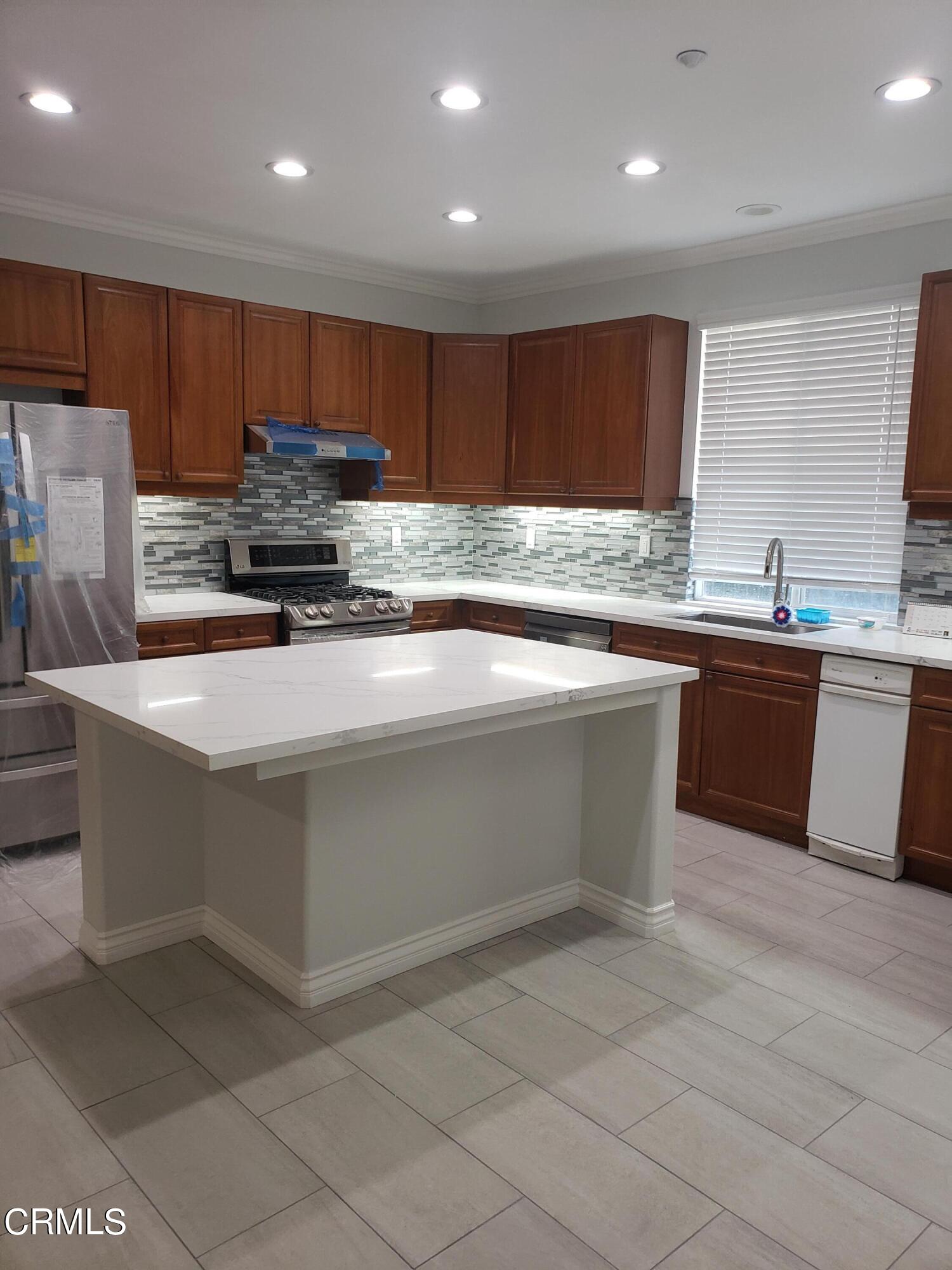 7454 Chanteclair Court Tujunga, CA 91042 - Photo 6 of 25 a kitchen with stainless steel appliances granite countertop a sink counter space cabinets and a large window