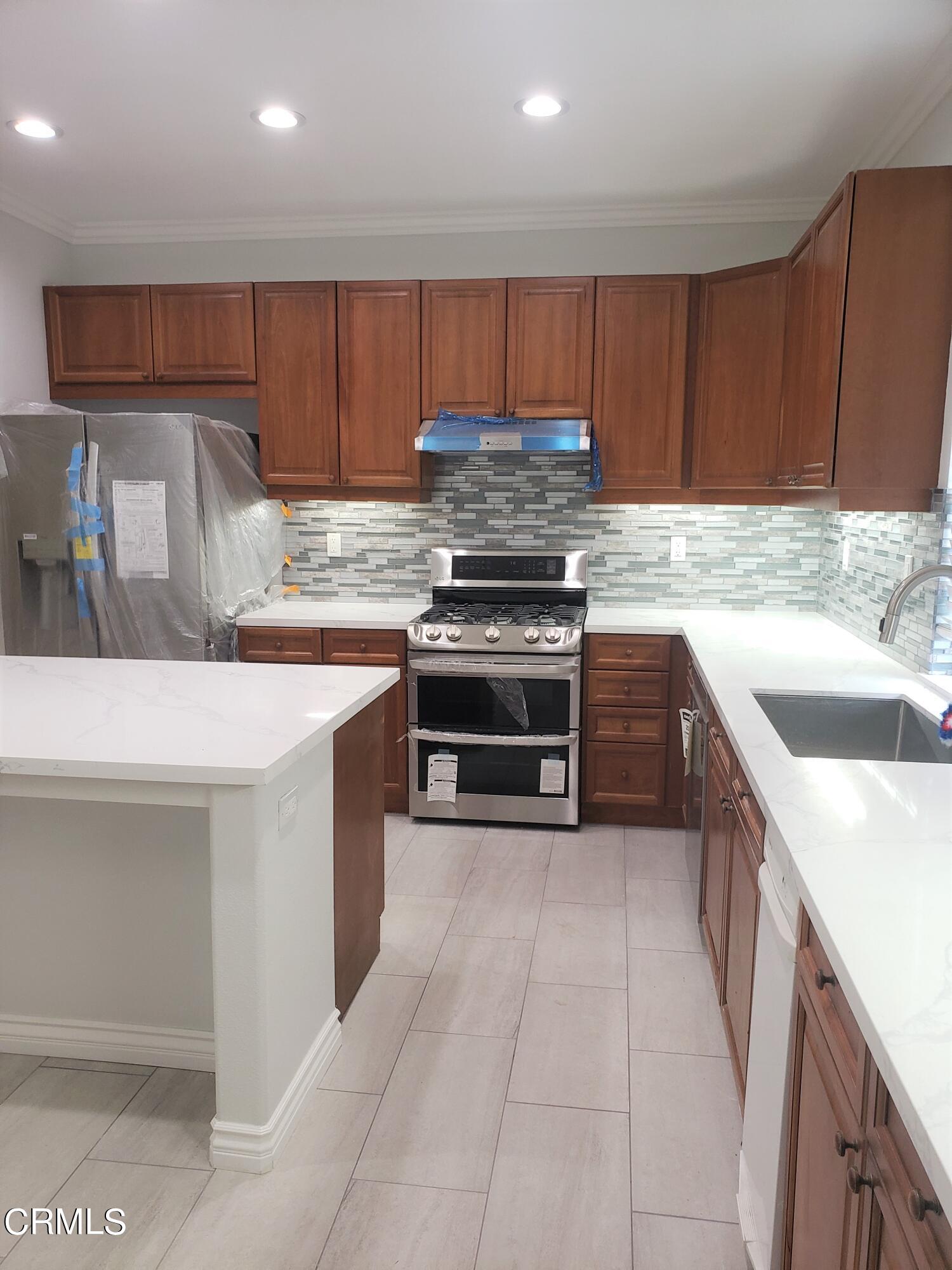 7454 Chanteclair Court Tujunga, CA 91042 - Photo 7 of 25 a kitchen with stainless steel appliances granite countertop a sink stove and a refrigerator