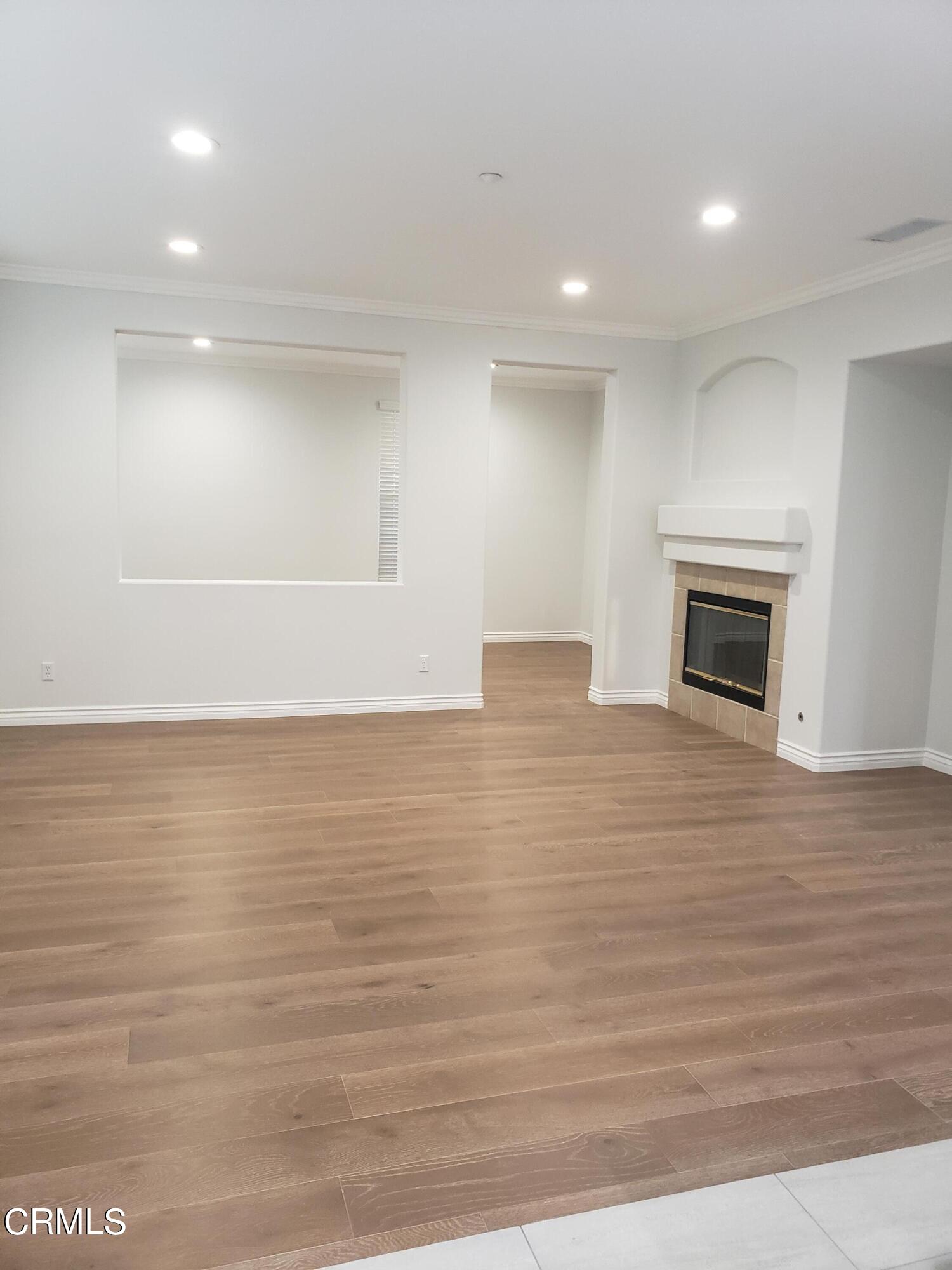 7454 Chanteclair Court Tujunga, CA 91042 - Photo 9 of 25 a view of an empty room with wooden floor and a fireplace