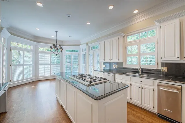 a kitchen with granite countertop a sink cabinets and wooden floor