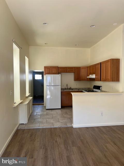 a kitchen with a refrigerator and a stove top oven