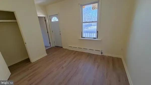an empty room with wooden floor and a window