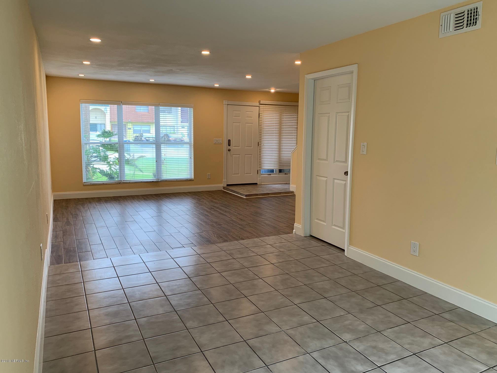 6108 Tuscony Circle Jacksonville, FL 32277 - Photo 4 of 9 an empty room with wooden floor and windows