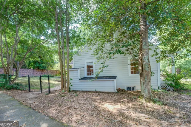 a view of a house with backyard and a tree