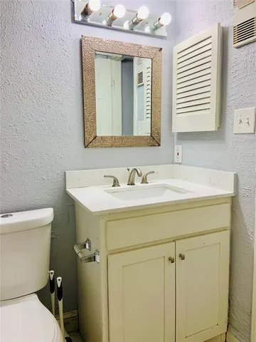 a bathroom with a sink a toilet and mirror