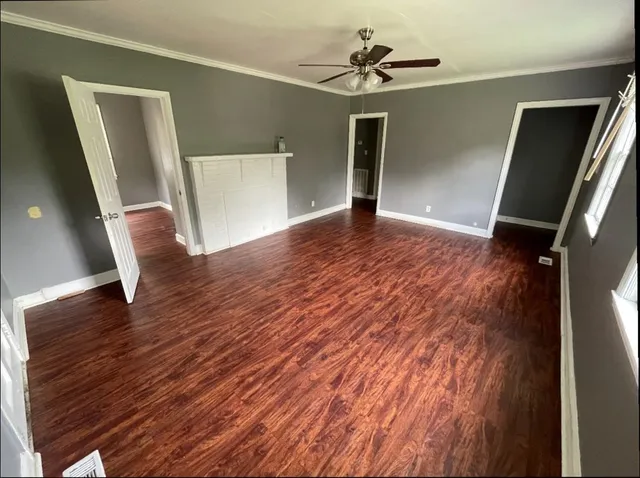 a view of empty room with wooden floor