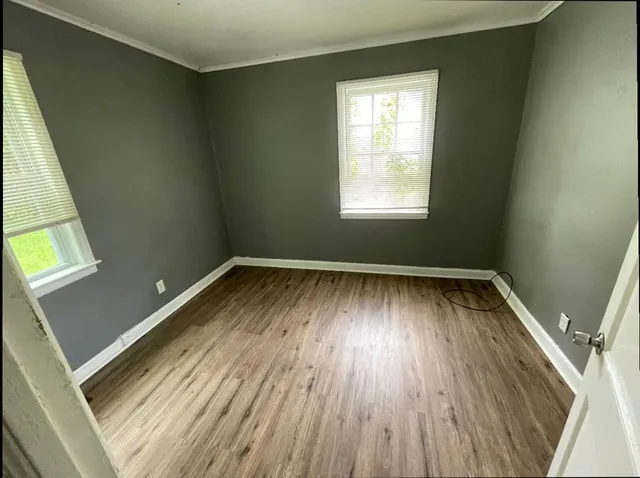 a view of a room with wooden floors and window
