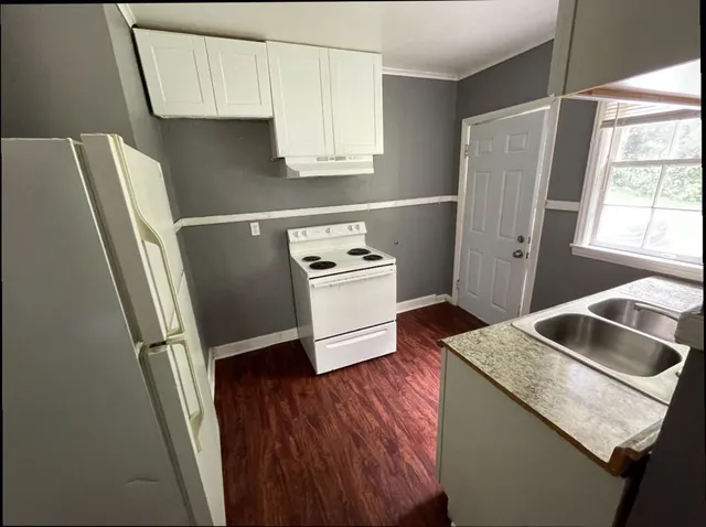 a kitchen with stainless steel appliances granite countertop a refrigerator a sink and a stove