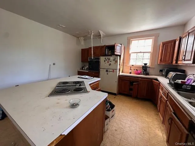 a kitchen with a stove a refrigerator and a sink