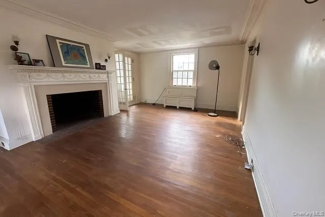 a view of an empty room with window and fire place