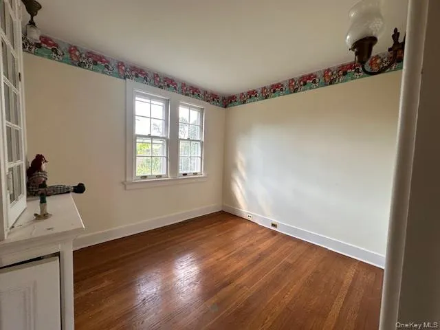 a big room with wooden floor mirror and windows