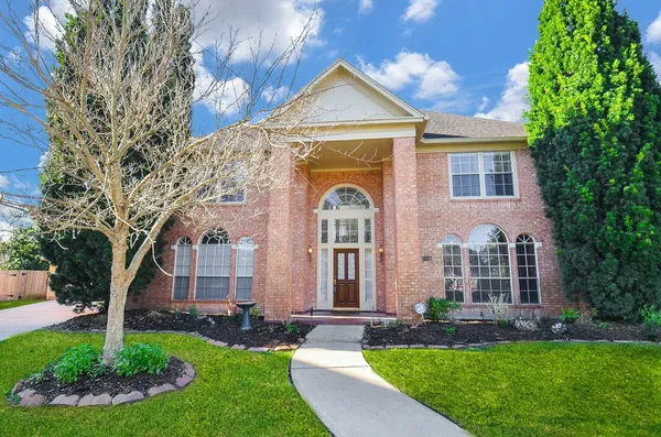 a front view of a house with a garden and plants