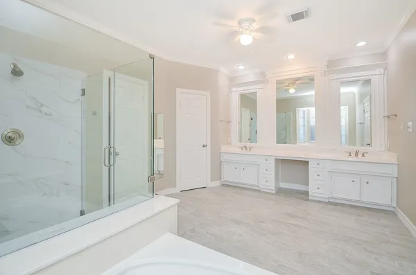 a large bathroom with a large mirror vanity and shower