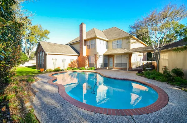 a view of a house with swimming pool and sitting area