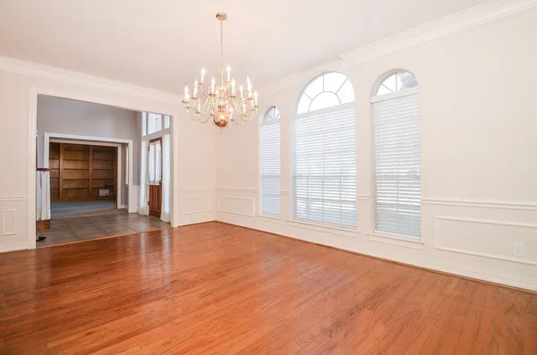 a view of a livingroom with wooden floor a ceiling fan and windows