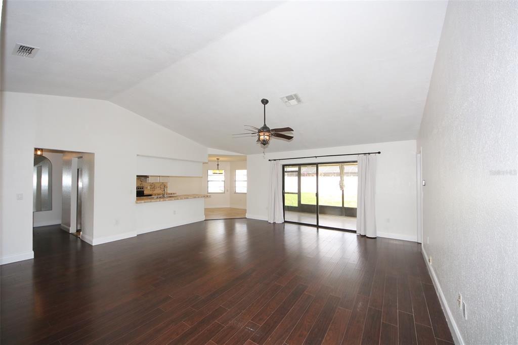 9297 Pickens Street Spring Hill, FL 34608 - Photo 18 of 40 a view of an empty room with wooden floor and a window