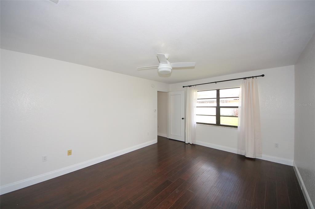 9297 Pickens Street Spring Hill, FL 34608 - Photo 21 of 40 an empty room with wooden floor and windows