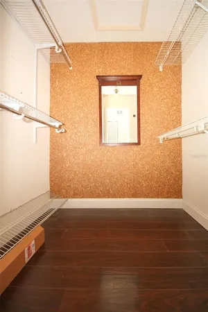 a view of a room with wooden floor chandelier and windows